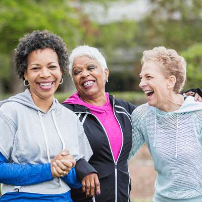 Three senior women smiling and laughing together, representing senior dental care aging patients