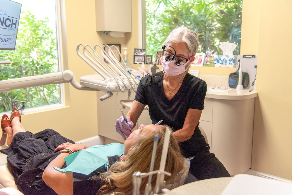 Dental hygienist cleaning patient's teeth