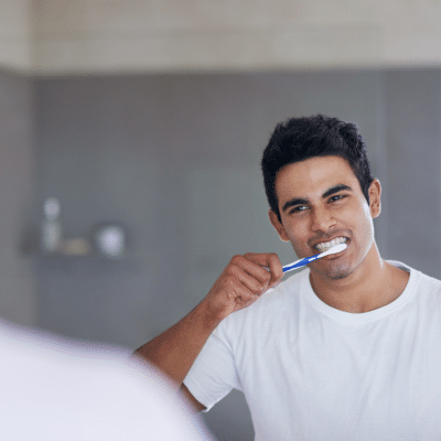 A man brushing his teeth, representing how oral health affects the body