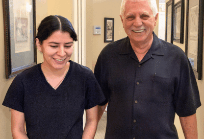 Male patient smiling and walking with team member, representing orthodontic treatment for adults