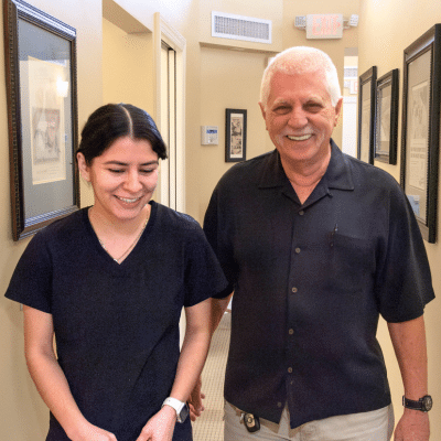 Male patient smiling and walking with team member, representing orthodontic treatment for adults