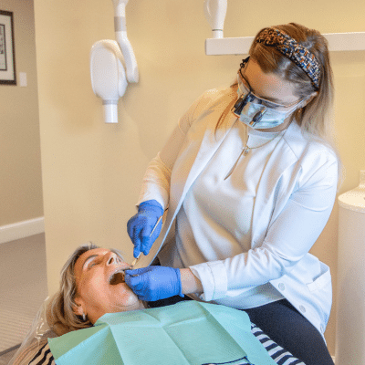 Dr. Newton working on a senior's teeth, representing benefits of dental implants for seniors