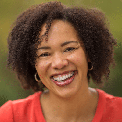 Older woman smiling, representing the debate between dental implants vs bridges