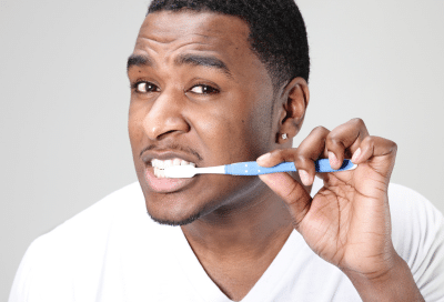 Man brushing teeth with toothbrush, representing how to prevent cavities