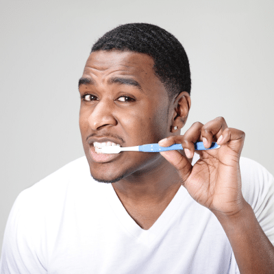 Man brushing teeth with toothbrush, representing how to prevent cavities