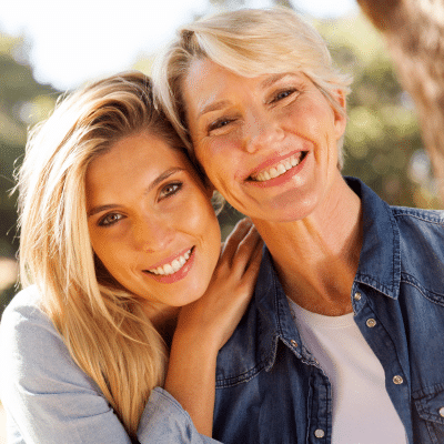 Two smiling women embracing outdoors, representing link between gum disease and diabetes